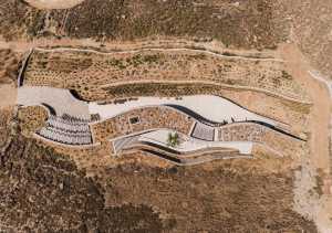 Xerolithi: pendientes de tierra y grava abrazan una vivienda