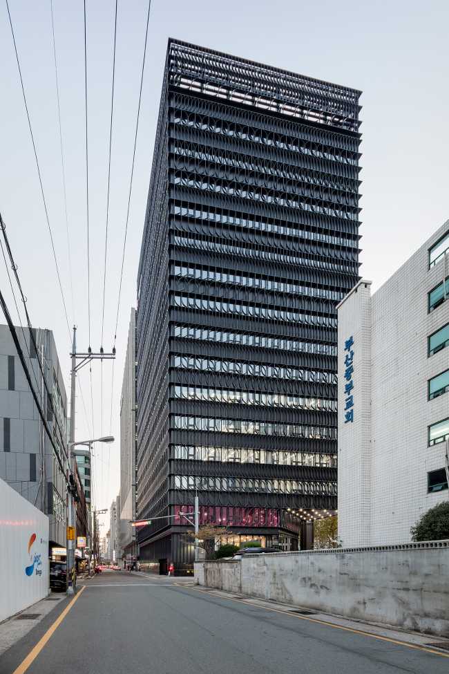 Elementos lineales para la fachada de la Torre Heungkuk de Busan teñidos de negro y fucsia