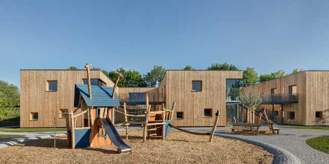 Scuola d’infanzia Kita II. Tre volumi in legno massiccio