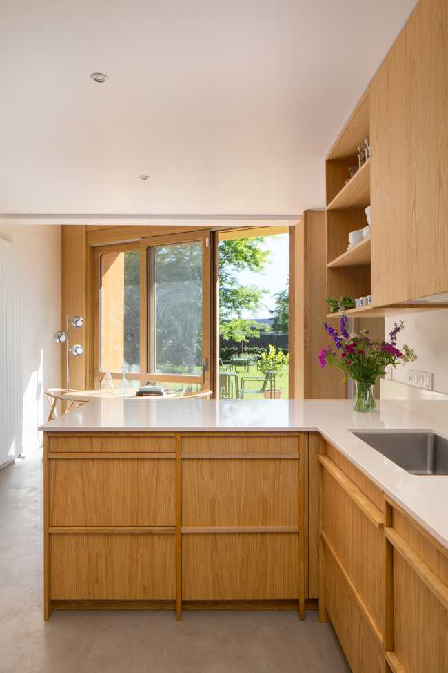 Madera de roble, hilo conductor en la renovación de la Villa de los años 90.