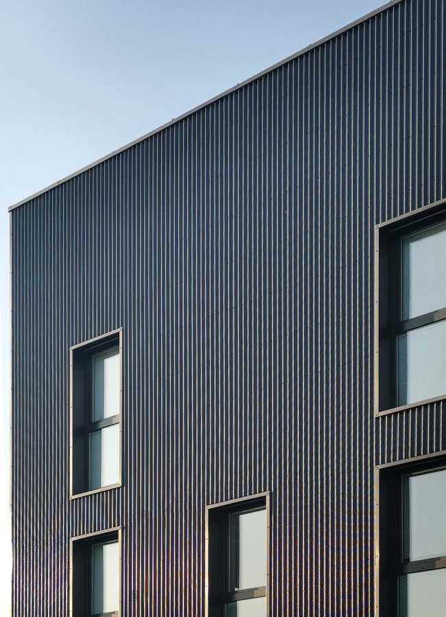 Renovación de la Oficina Central. Fachadas metálicas inspiradas en la vocación industrial del lugar