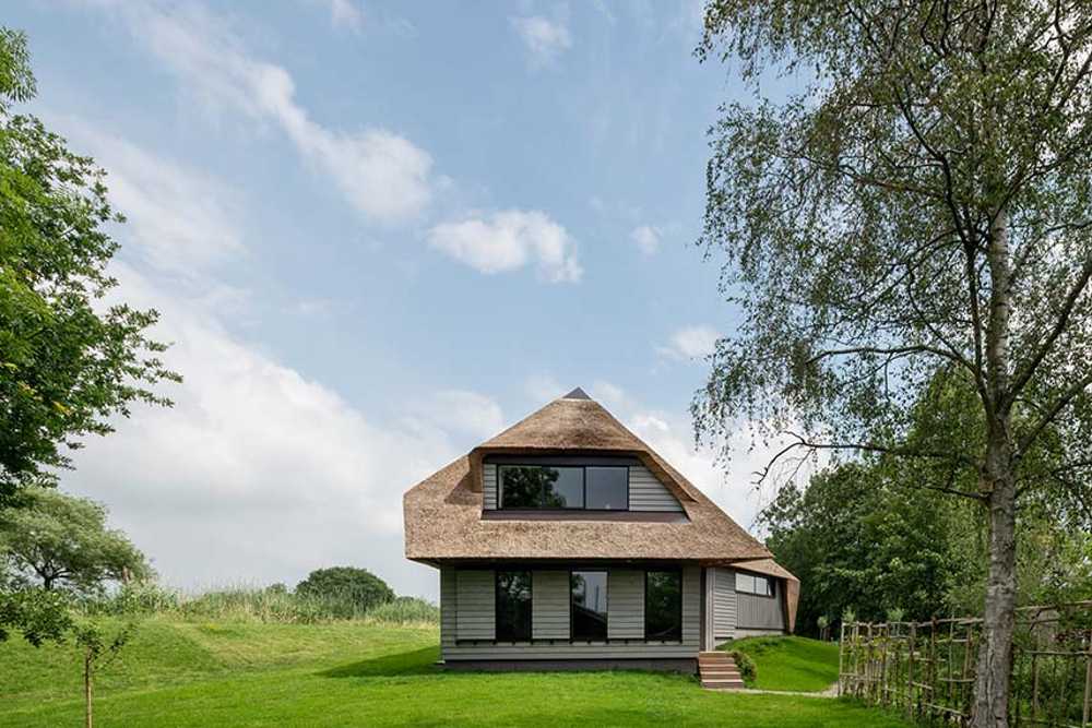 Dutch Dike House. A stunning glass fissure transforms the traditional structure