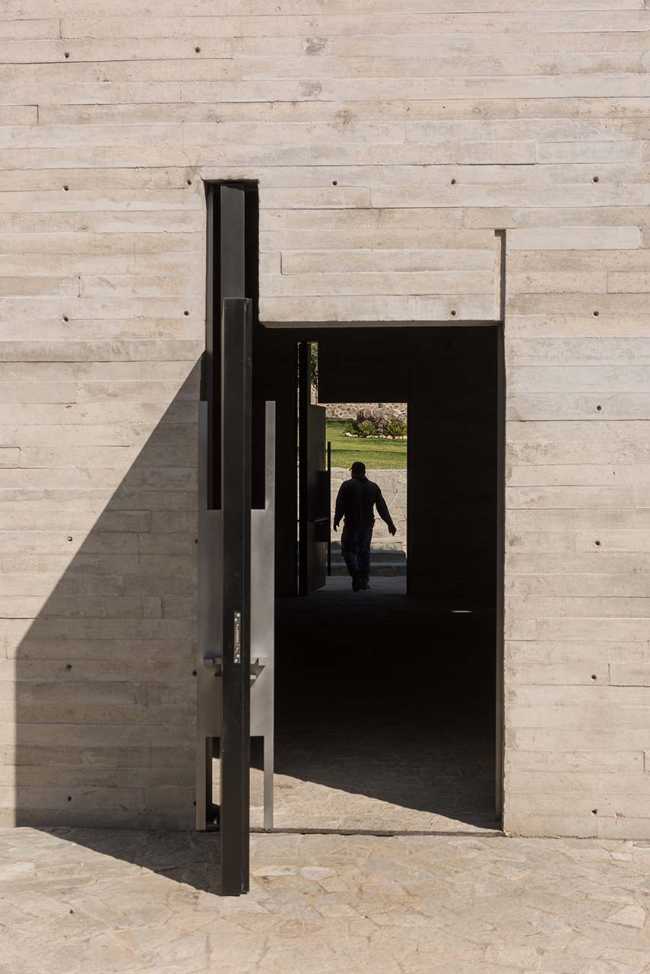 Cappella RLJ. Calcestruzzo e acciaio a vista a contrasto con i materiali naturali