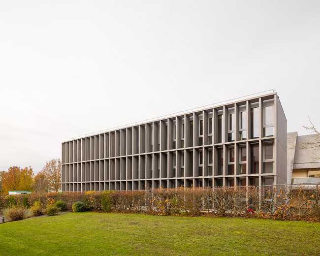 Expansion of the ASSIA headquarters. Volume in wood, concrete, and glass.