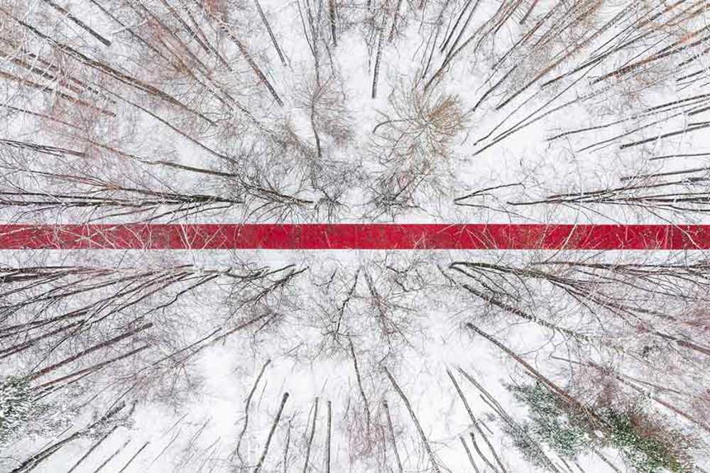 Nowhere. A red thread in the white landscape, effects of perspective and infinity