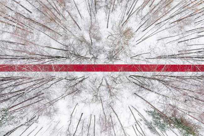 Nowhere. A red thread in the white landscape, effects of perspective and infinity