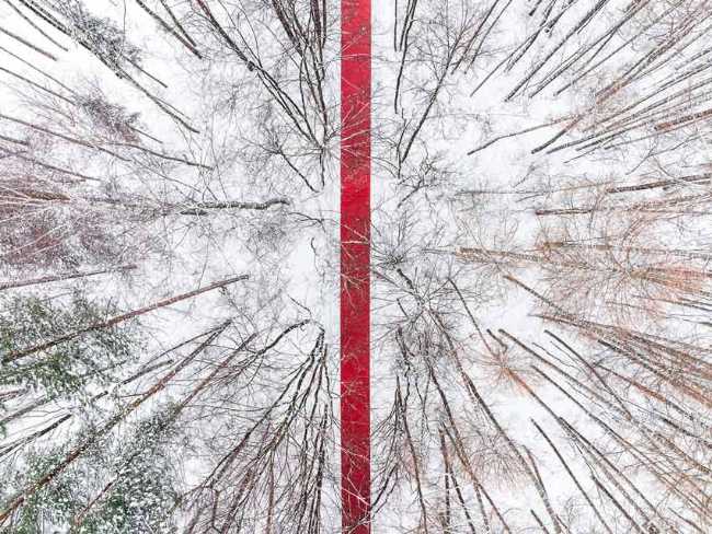 Nowhere. A red thread in the white landscape, effects of perspective and infinity