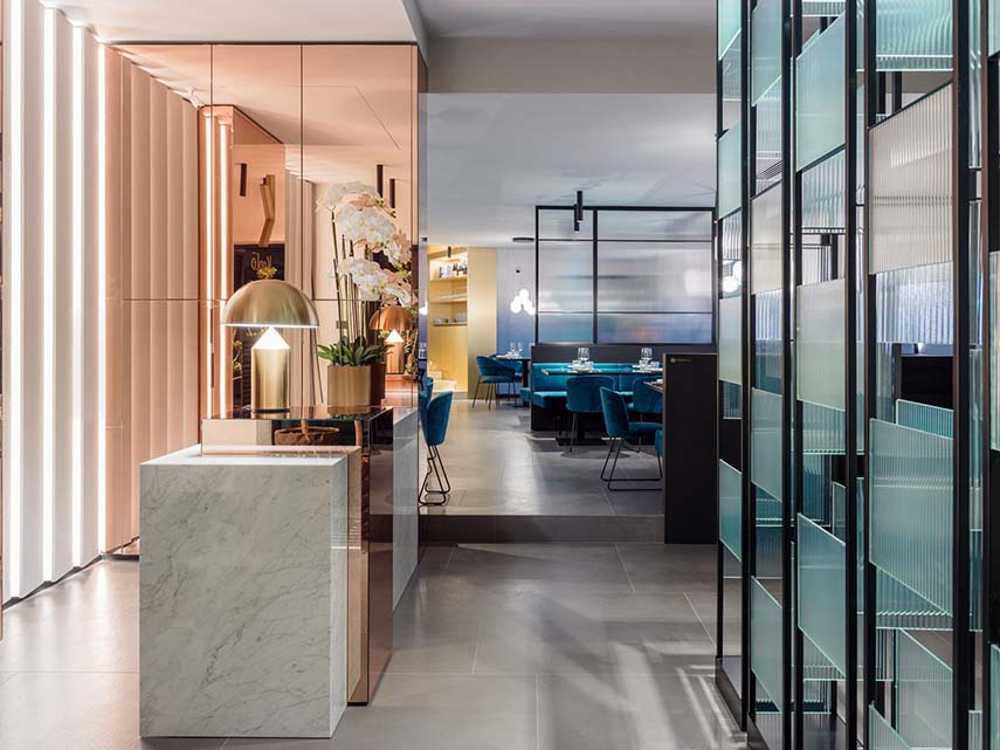 Restaurante KANTO con estructuras tubulares, mármol, latón y terciopelo