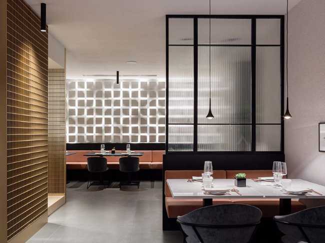 Restaurante KANTO con estructuras tubulares, mármol, latón y terciopelo