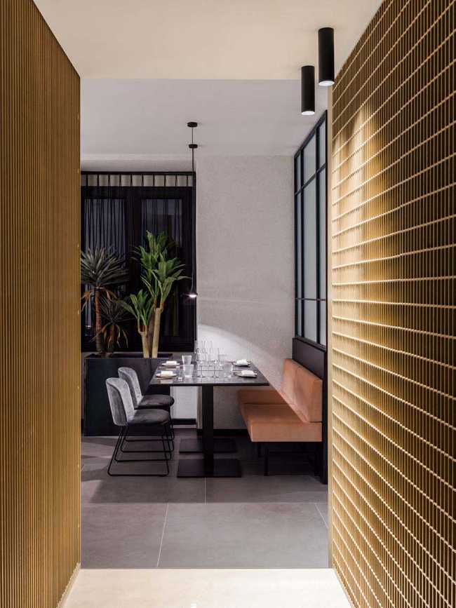 Restaurante KANTO con estructuras tubulares, mármol, latón y terciopelo