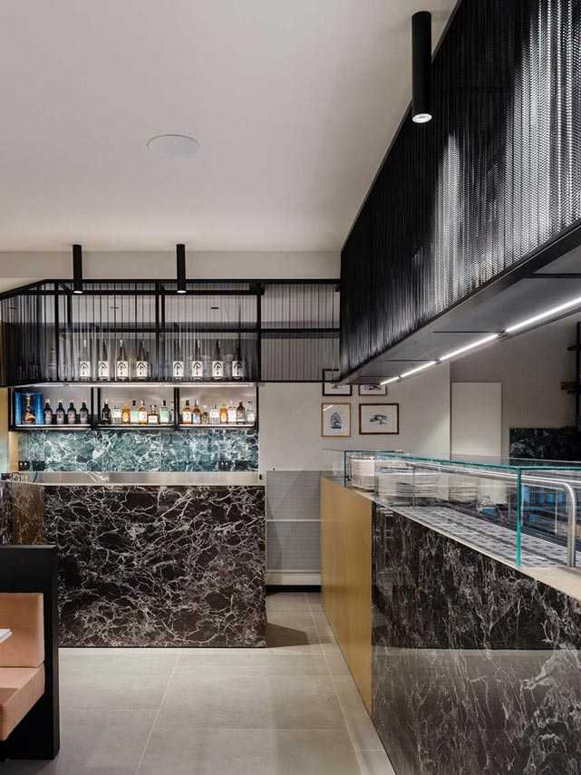 Restaurante KANTO con estructuras tubulares, mármol, latón y terciopelo