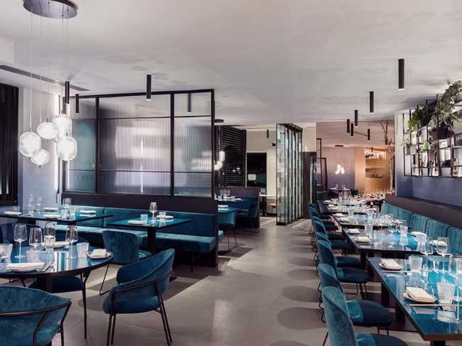 Restaurante KANTO con estructuras tubulares, mármol, latón y terciopelo