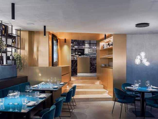 Restaurante KANTO con estructuras tubulares, mármol, latón y terciopelo