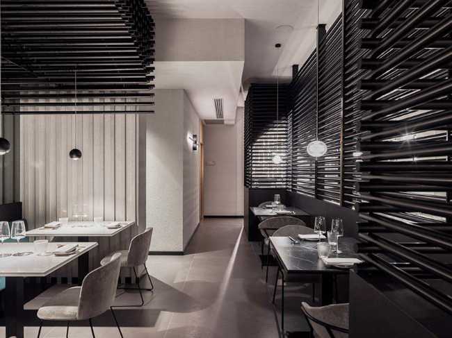 Restaurante KANTO con estructuras tubulares, mármol, latón y terciopelo