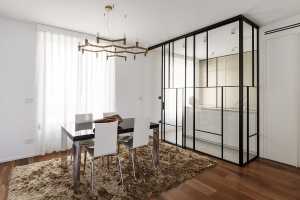 Cucina-serra e boiserie fluide in un appartamento torinese