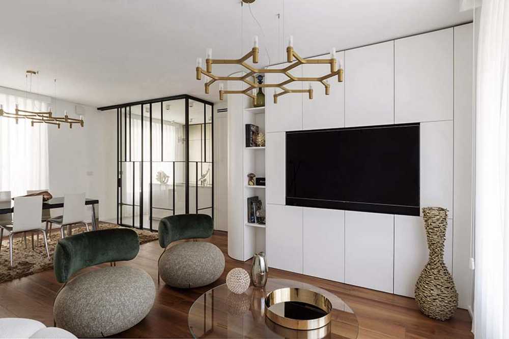 Cocina invernadero y paneles de madera fluidos en un apartamento turinés.
