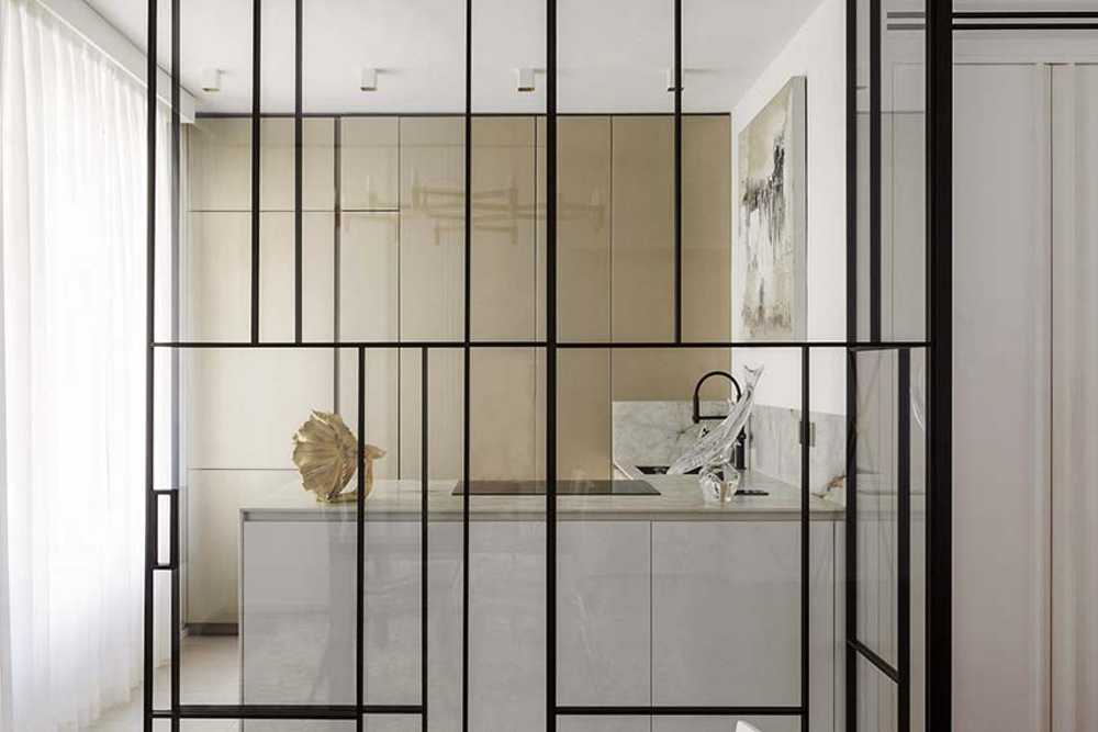 Cocina invernadero y paneles de madera fluidos en un apartamento turinés.