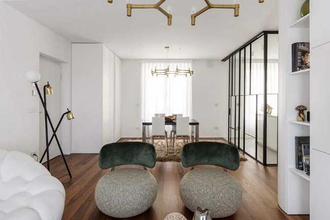 Cocina invernadero y paneles de madera fluidos en un apartamento turinés.