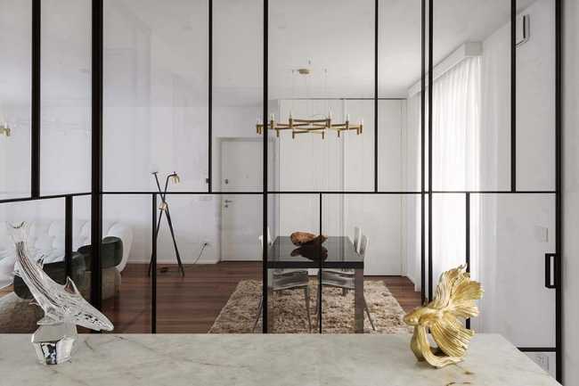 Cocina invernadero y paneles de madera fluidos en un apartamento turinés.