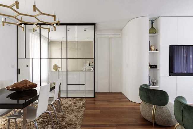 Cocina invernadero y paneles de madera fluidos en un apartamento turinés.