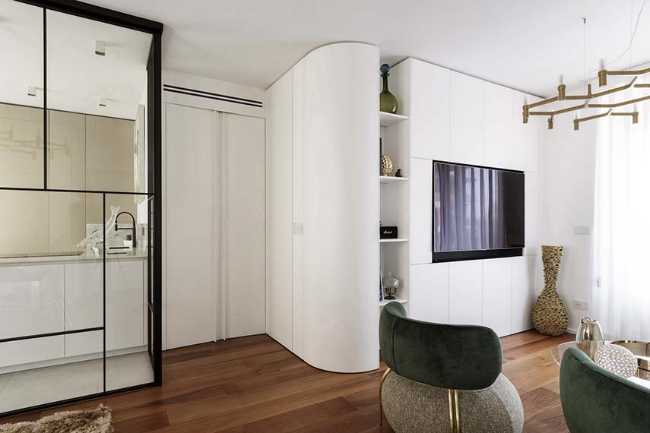 Cocina invernadero y paneles de madera fluidos en un apartamento turinés.