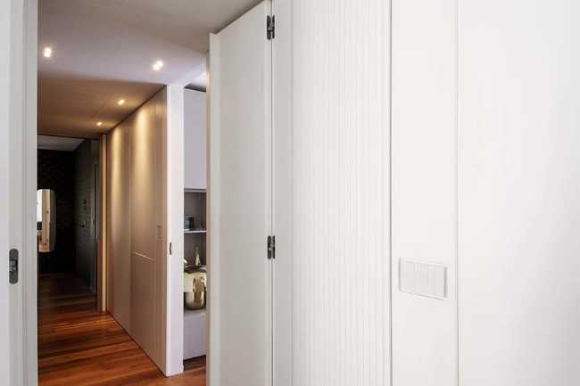 Cocina invernadero y paneles de madera fluidos en un apartamento turinés.