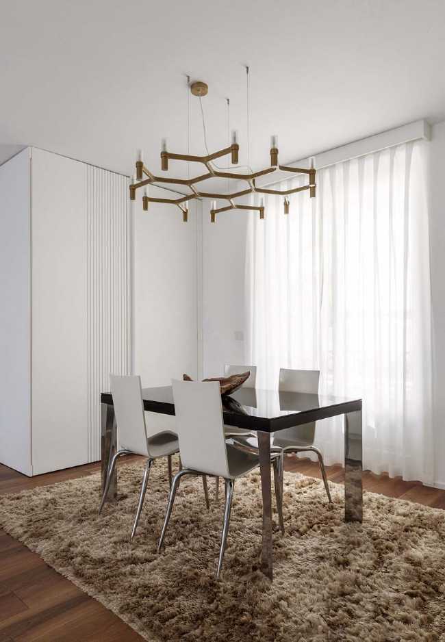 Cocina invernadero y paneles de madera fluidos en un apartamento turinés.