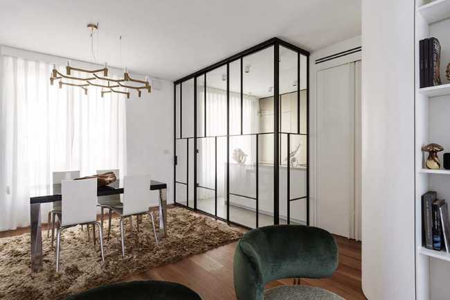 Cocina invernadero y paneles de madera fluidos en un apartamento turinés.