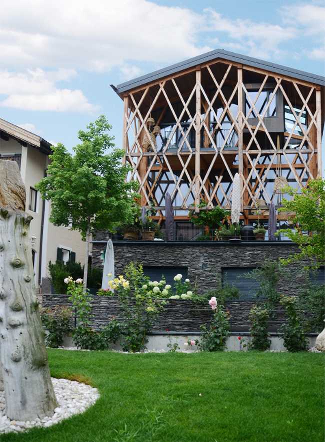 Struttura eterea in legno che poggia su un basamento in pietra frastagliato