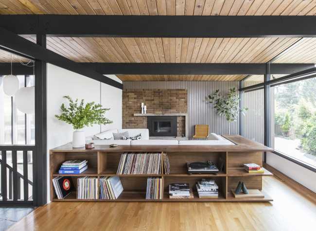 A wooden bookcase wraps around the sofa
