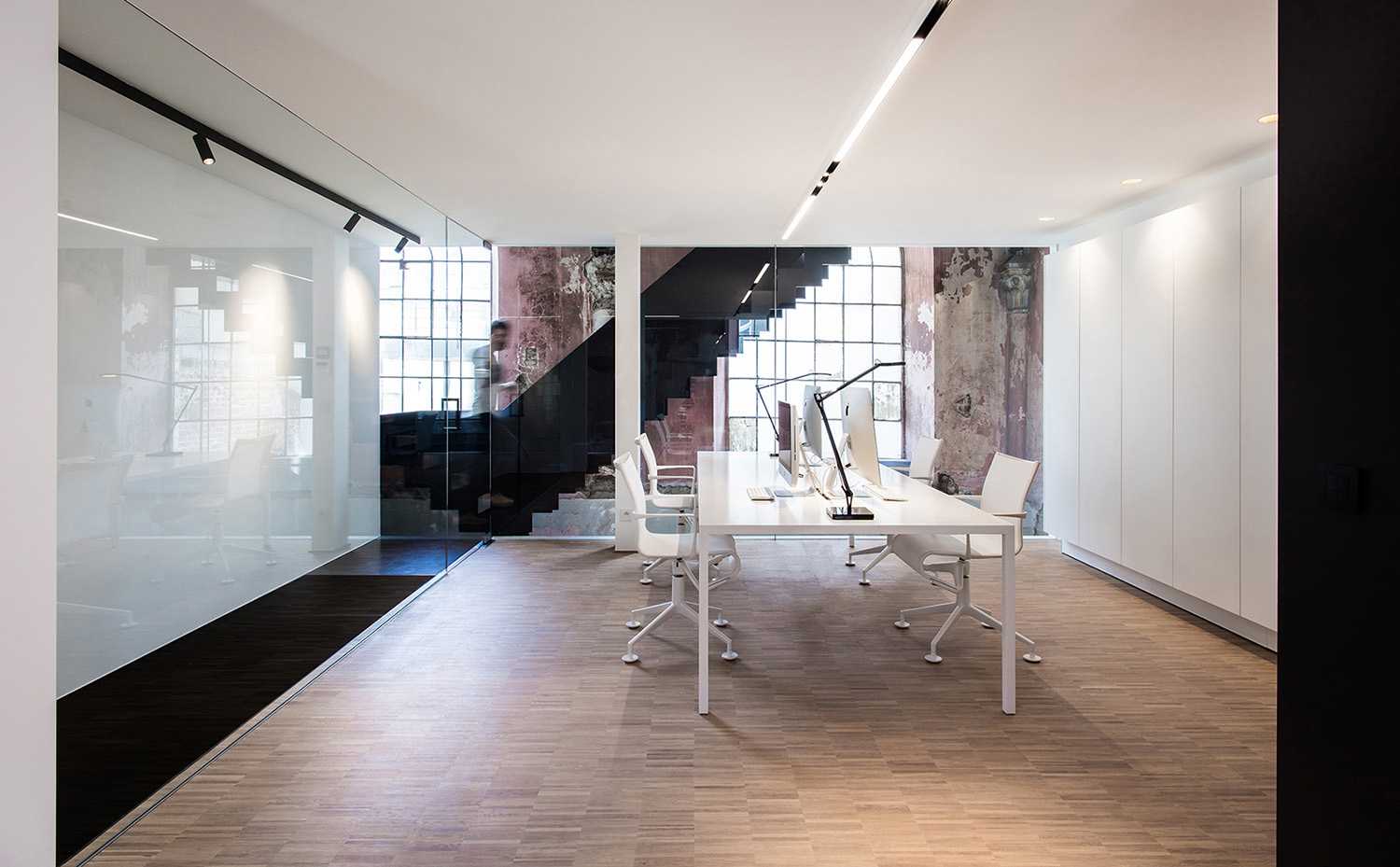 Minimal meeting room in contrast with the existing walls of the church