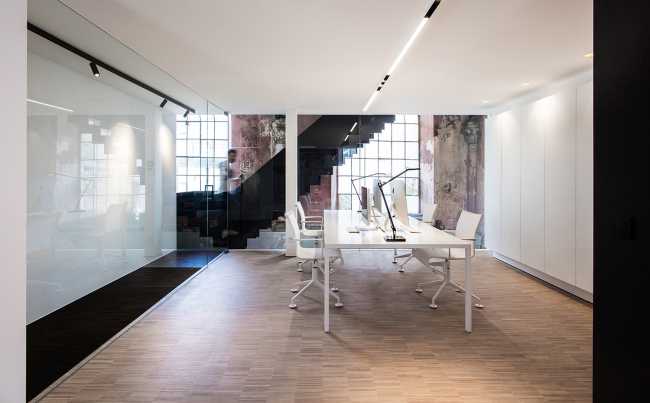 Minimal meeting room in contrast with the existing walls of the church