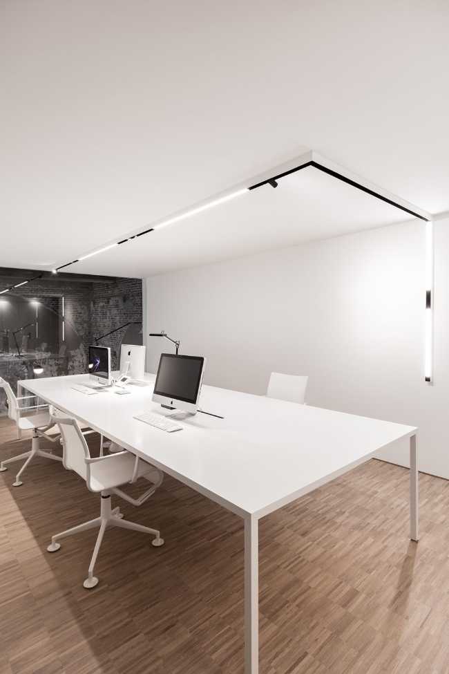 Minimalist and completely white office in contrast to the old structure