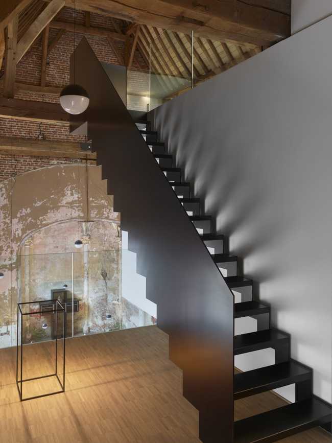 The staircase is enclosed by a handrail composed of a single metal plate