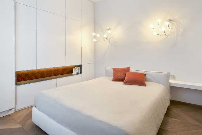 La zona notte completamente sui toni del bianco e parquet chairo