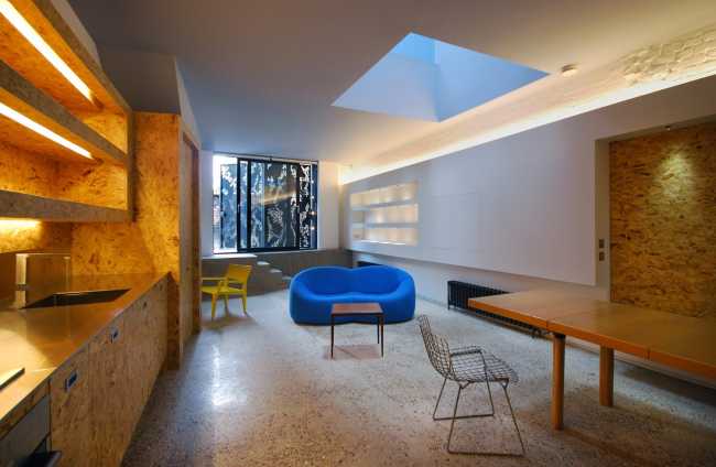 La cucina al piano inferiore realizzata su misura in legno riciclato