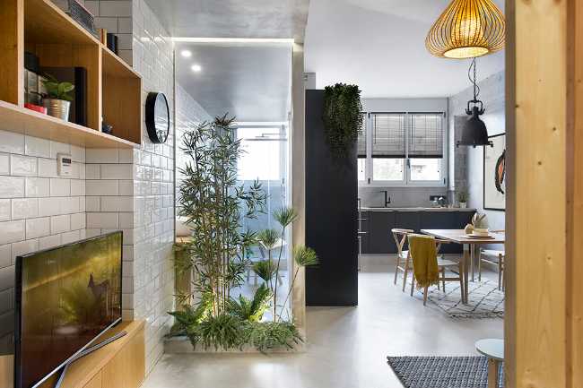 The entrance through the small corridor with the wooden wall frames the glazed bathroom