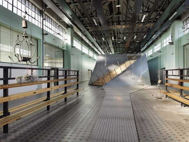 Una passarella in metallo si appoggia sul vecchio pavimento