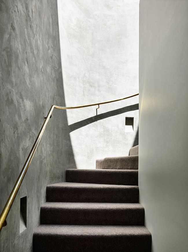 The internal staircase with the brass handrail