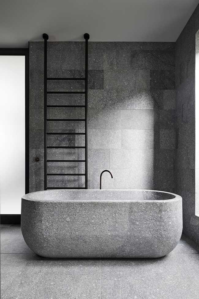 The stone bathtub and the bathroom wall tiles