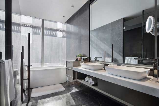 The bathroom has a large window in which the bathtub is positioned