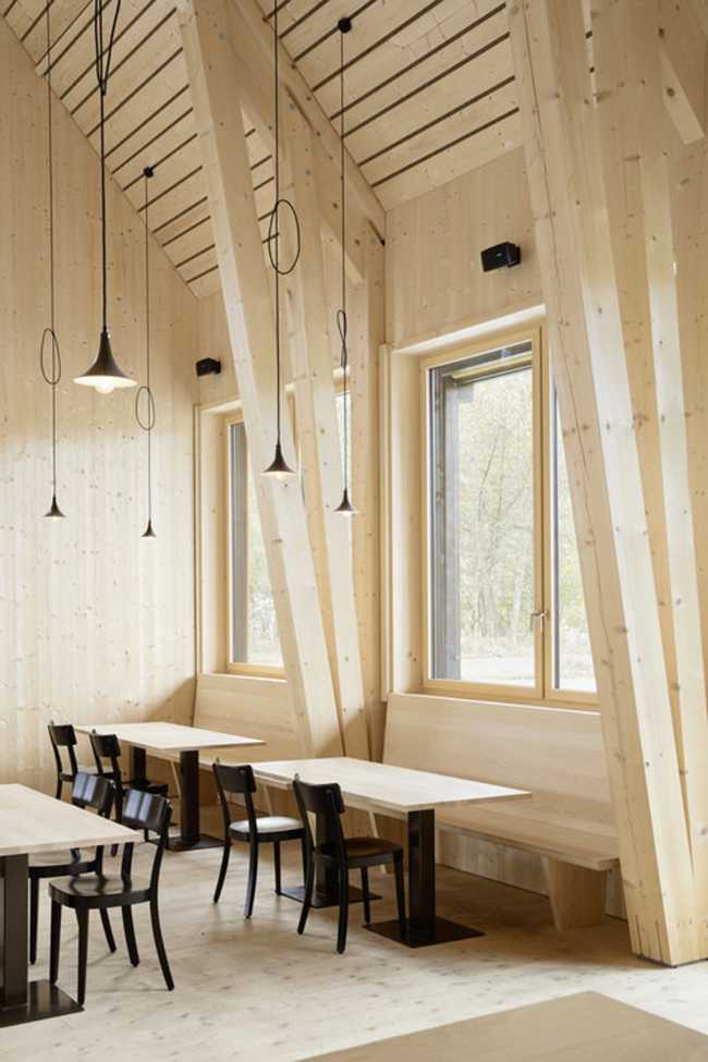 Interior del restaurante con mesas y ventanas con vistas al paisaje