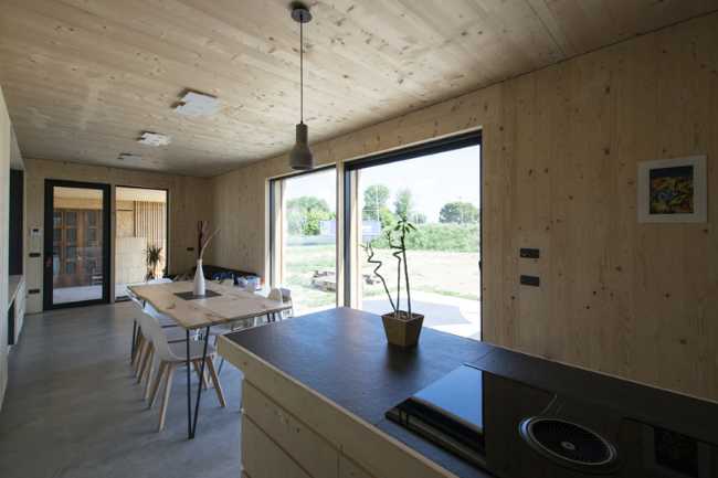 Casa pasiva interior de madera con cocina y ventanal