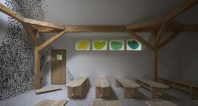 Interior of the chapel in white plaster with wooden structural elements