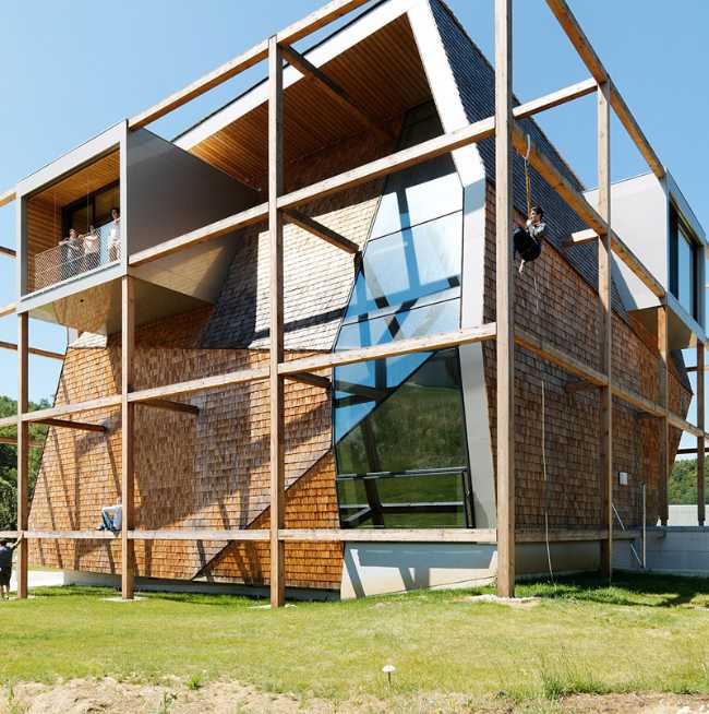 Exterior of the building intended for offices with glass windows, exposed wood structure and prefabricated panels