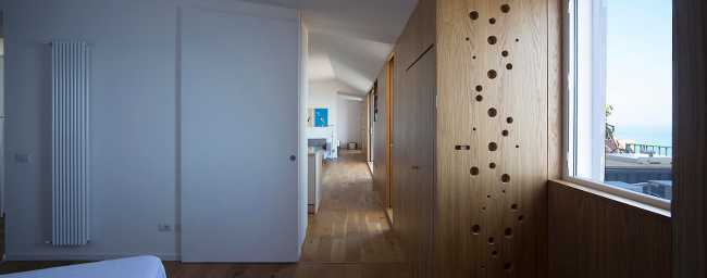 Corridoio in legno e bianco con finestra sul mare