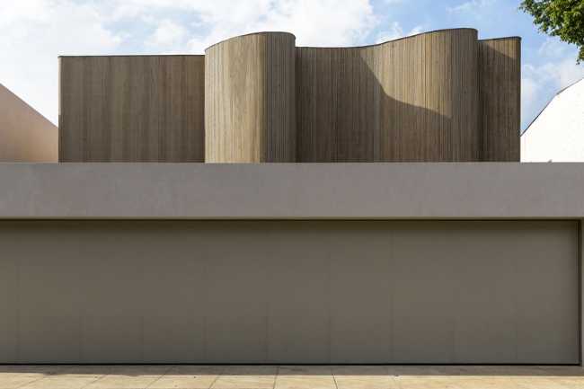 Basamento in intonaco bianco e aggiunta di un volume in legno organico