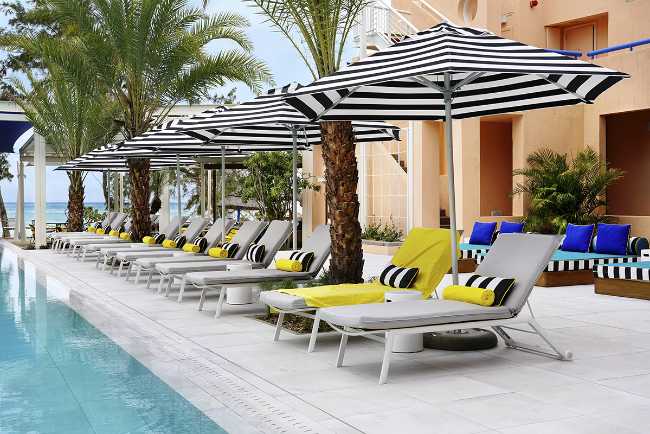 piscina hotel diseño sombrillas tumbonas color