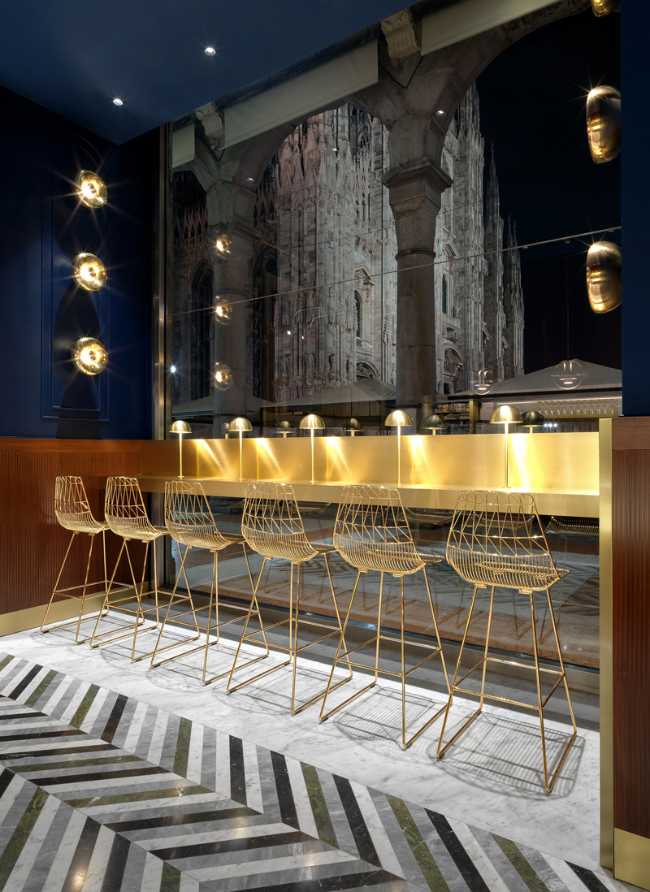 sedute e bancone color oro e pavimento in pietra