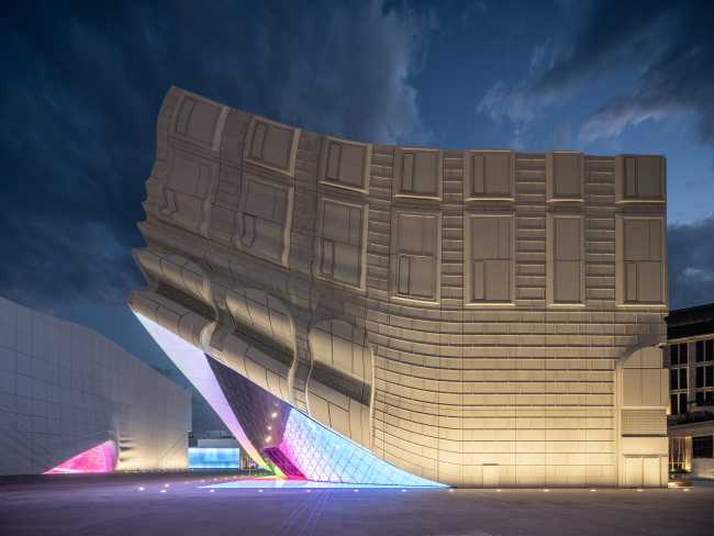 fachada nocturna paneles de hormigón oro gris